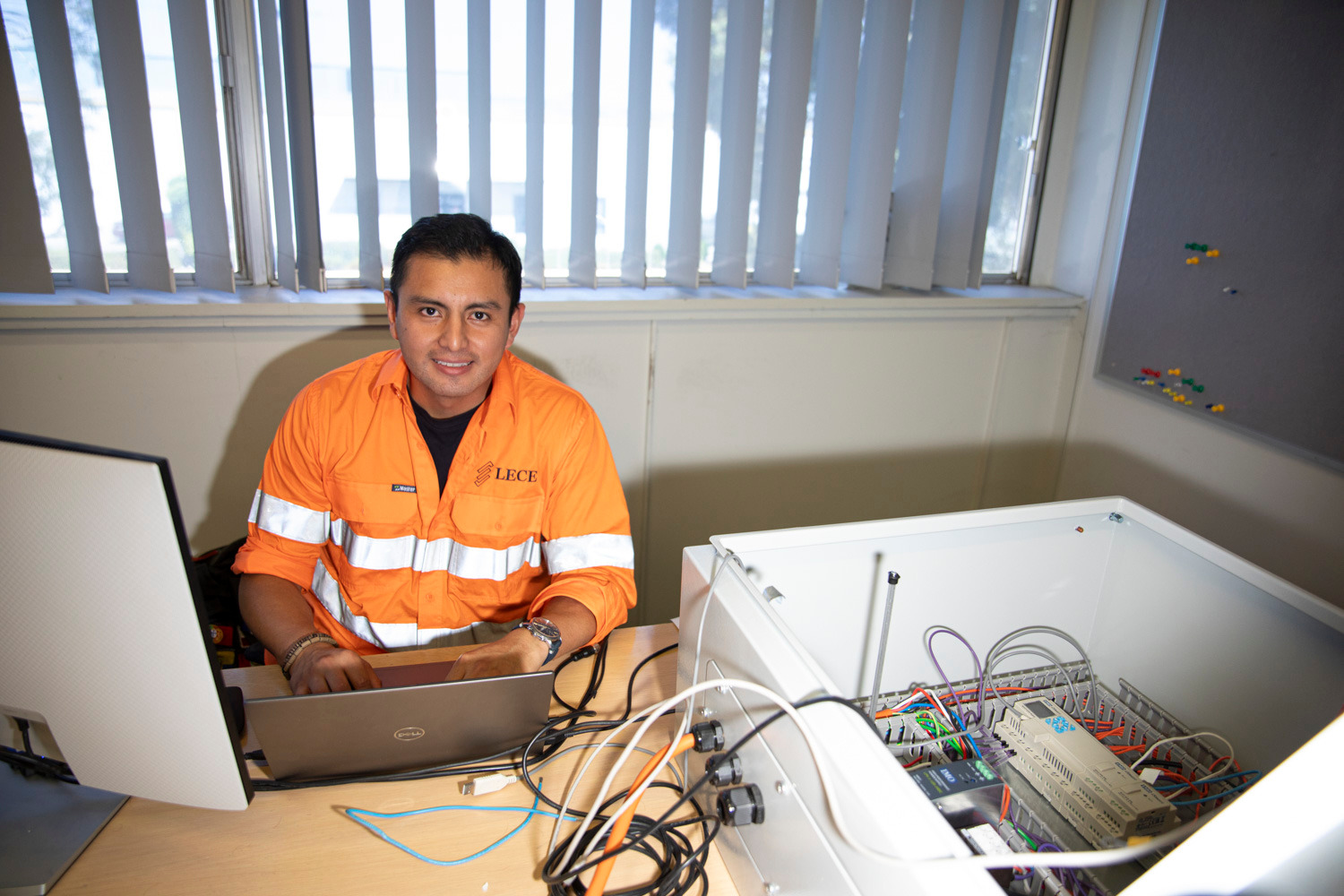 Technical workspace with laptop and electrical control enclosure